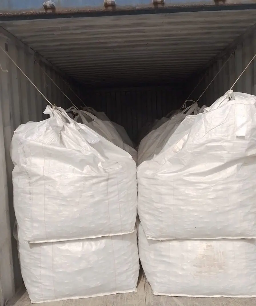 Rows of white bulk bags loaded inside a shipping container