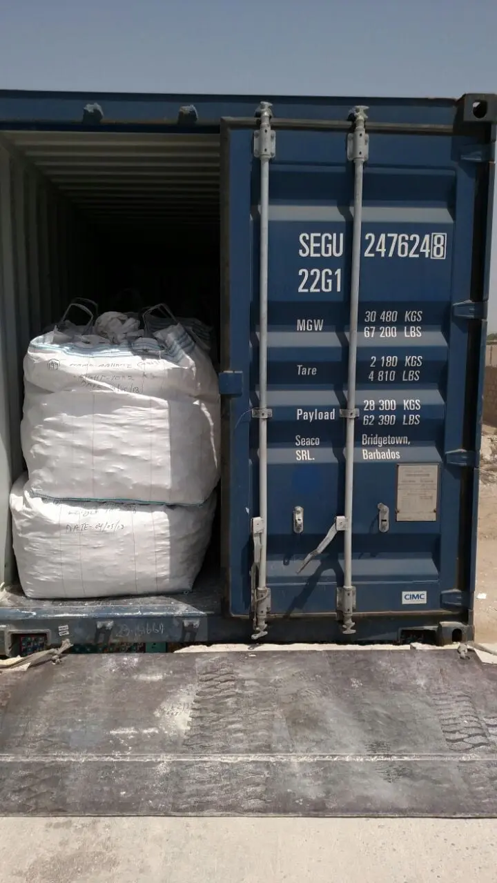 White bulk bags being loaded into an open shipping container